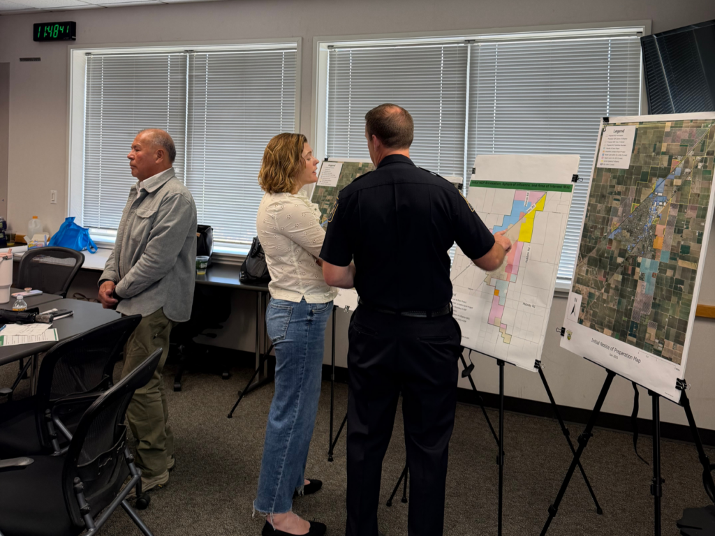 A woman and a police officer discuss a map displayed on an easel at the community workshop.